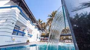 Un hotel con piscina y una cascada.