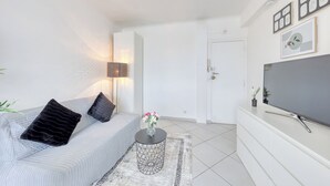 Una sala de estar moderna con un sofá, una lámpara, un televisor y una puerta.