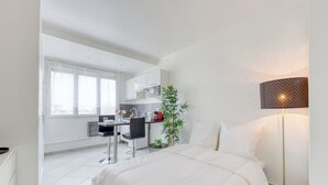 Una habitación de hotel moderna con cama, escritorio y kitchenette.