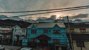A blue building with a traditional architectural style, surrounded by mountains and power lines.
