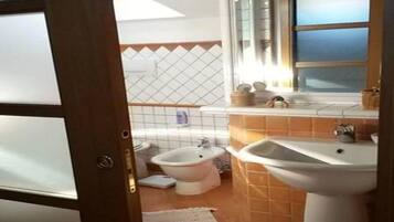 Een haardroger, handdoeken, zeep, toiletpapier