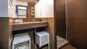 Une salle de bain moderne avec une douche, un lavabo et un miroir.