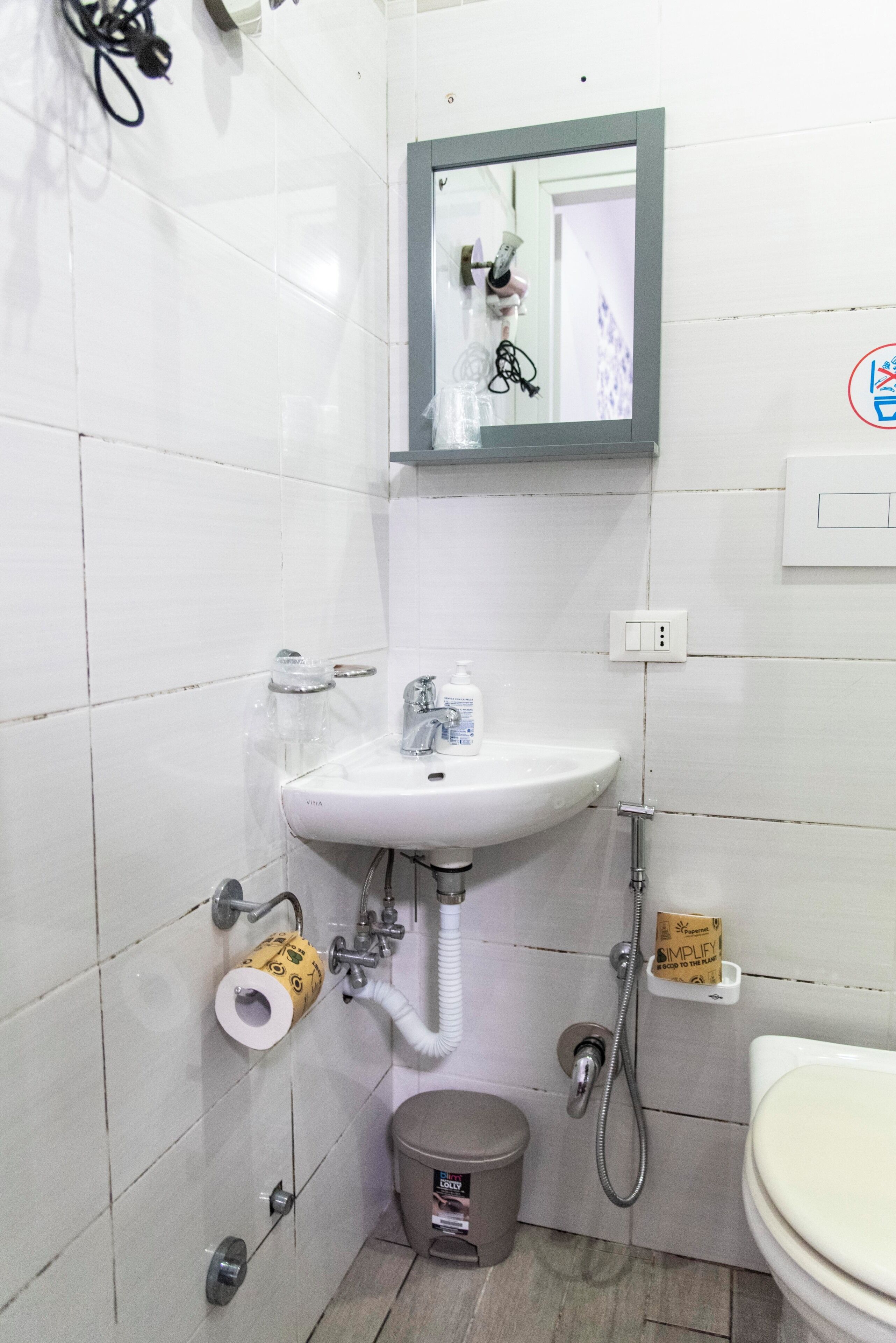 A bathroom with a white sink, a toilet, and a shower.