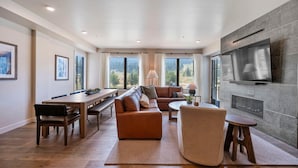 A modern living room with a large sofa, a dining table, and a fireplace. - Slope! There It Is! | Includes Two 1-Day Lift Tickets (Tamarack)