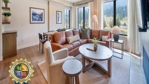 A spacious living room with a large sectional sofa, a round coffee table, and a dining area. - Slope! There It Is! | Includes Two 1-Day Lift Tickets (Tamarack)
