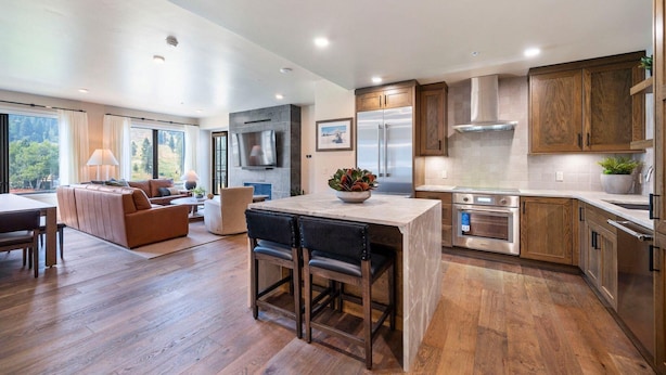 A modern kitchen with wooden cabinets, stainless steel appliances, and a central island. - Slope! There It Is! | Includes Two 1-Day Lift Tickets (Tamarack)
