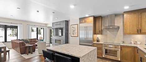 Una cocina moderna con una isla central, electrodomésticos de acero inoxidable y armarios de madera.