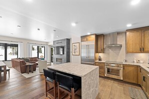 Una cocina moderna con una isla central, electrodomésticos de acero inoxidable y armarios de madera.