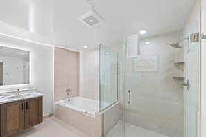 A modern bathroom with a glass-enclosed shower, a freestanding bathtub, and a vanity with a large mirror. - Slope! There It Is! | Exclusive Tamarack Perks (Tamarack)
