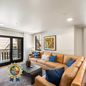 A modern living room with a leather sofa, a coffee table, and a framed picture on the wall.