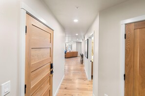 A hallway with wooden doors, a light-colored floor, and recessed ceiling lighting.