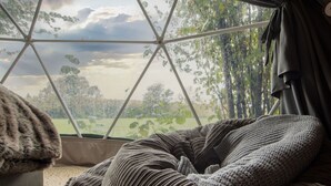 A cozy room with a large window, a comfortable chair, and a view of a green landscape. - Wonderful  villa for 4 people with WIFI and pets allowed (Crowborough)
