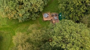 An aerial view of a wooden deck with a circular table and chairs, surrounded by dense green foliage. - Wonderful  villa for 4 people with WIFI and pets allowed (Crowborough)