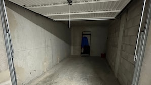 Ein Lagerraum mit Betonwänden, einer Metalttür und einer Decke mit Lüftungsanlage.