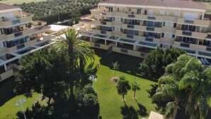 A multi-story hotel with balconies, a central courtyard, and a view of the surrounding landscape. - Charming 3-bedroom apartment with terrace and garden access in Denia (Denia)