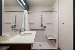 Une salle de bain moderne avec une douche, un lavabo et un miroir.