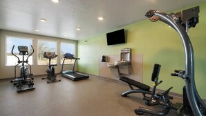 Ein Fitnessstudio mit Laufbändern, Crosstrainern und Gewichten.