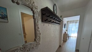 Un corridoio con un grande specchio decorativo, un orologio e un appendiabiti.