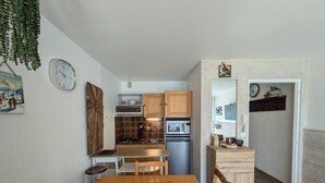 Una cucina funzionale con mobili in legno, un forno a microonde e un frigorifero.