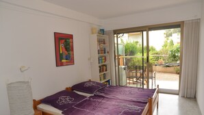 A bedroom with a bed, a bookshelf, and a view of the outdoors. - Spacious 3P with terrace and pool in Menton (Menton)