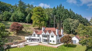 Uma casa grande e moderna com um pátio amplo e um gramado bem cuidado.