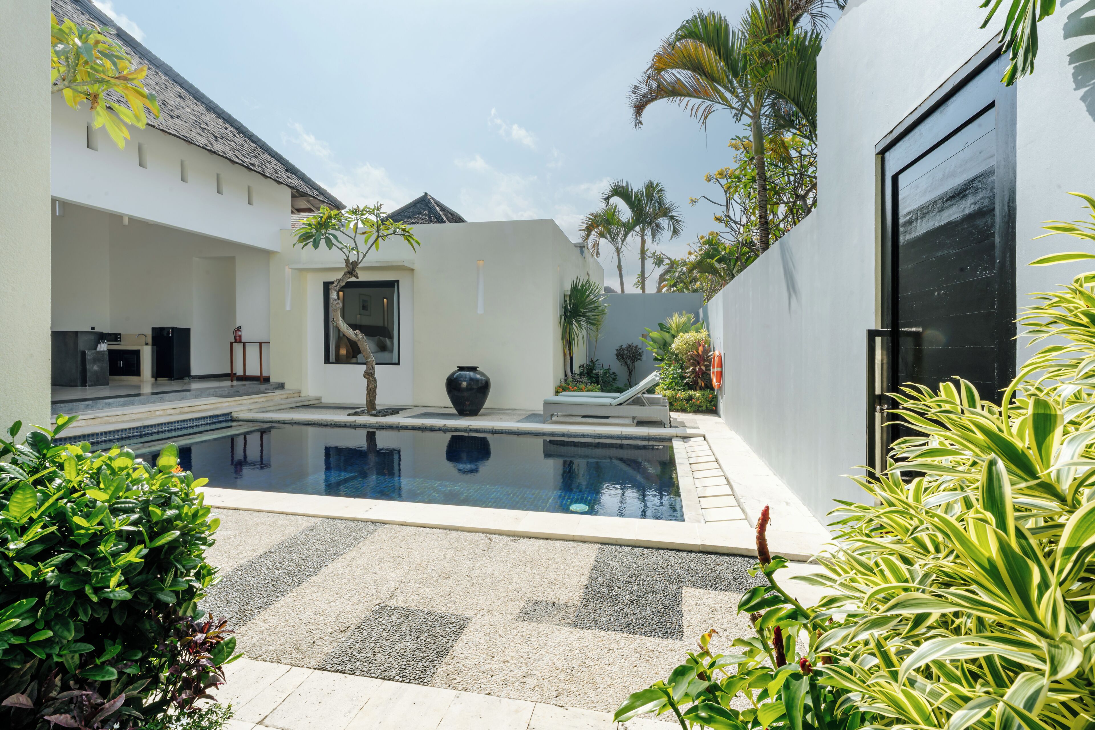 Una casa moderna con piscina, zona pranzo e garage.