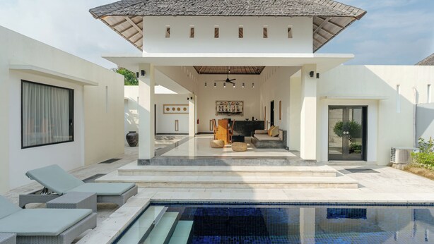 A modern house with a swimming pool, outdoor seating, and a covered patio area. - The Seminyak Suites Private Villas  (Seminyak)