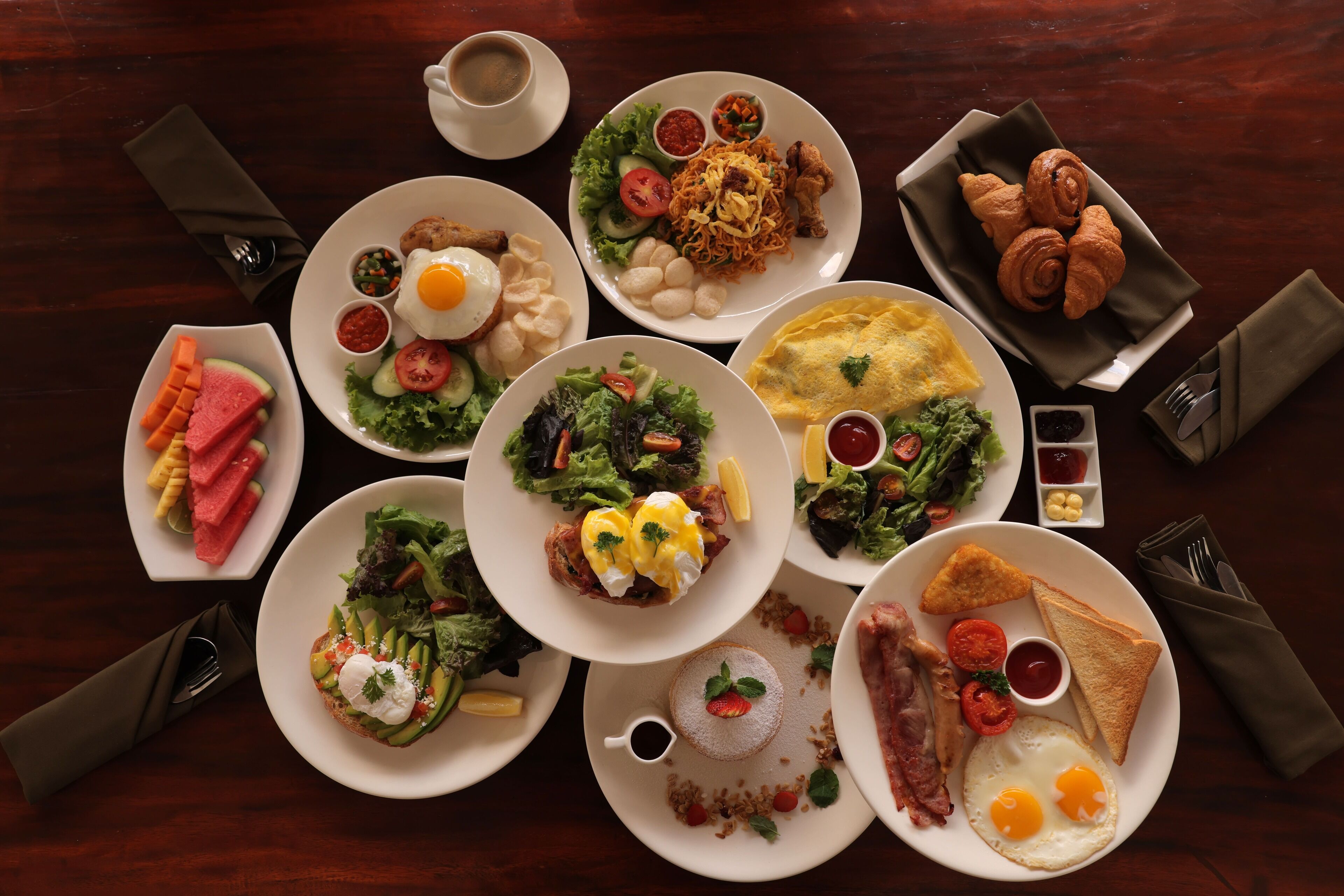 A variety of dishes on a table, including eggs, toast, and salads.