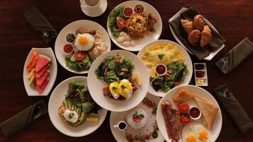 A variety of dishes on a table, including eggs, toast, and salads.