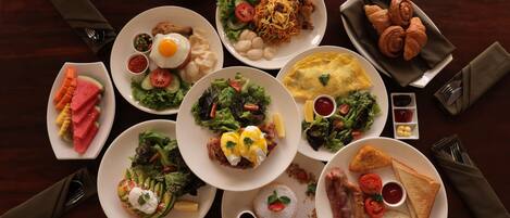 A variety of dishes on a table, including eggs, toast, and salads.