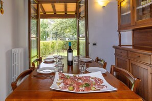 Une table à manger dressée pour six personnes, avec des assiettes, des couverts et une bouteille de vin.