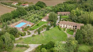 An aerial view of a countryside property with a swimming pool, multiple buildings, and surrounding fields. - Apartment 'Biancospino' with Shared Pool, Wi-Fi, and Air Conditioning (Santa luce)