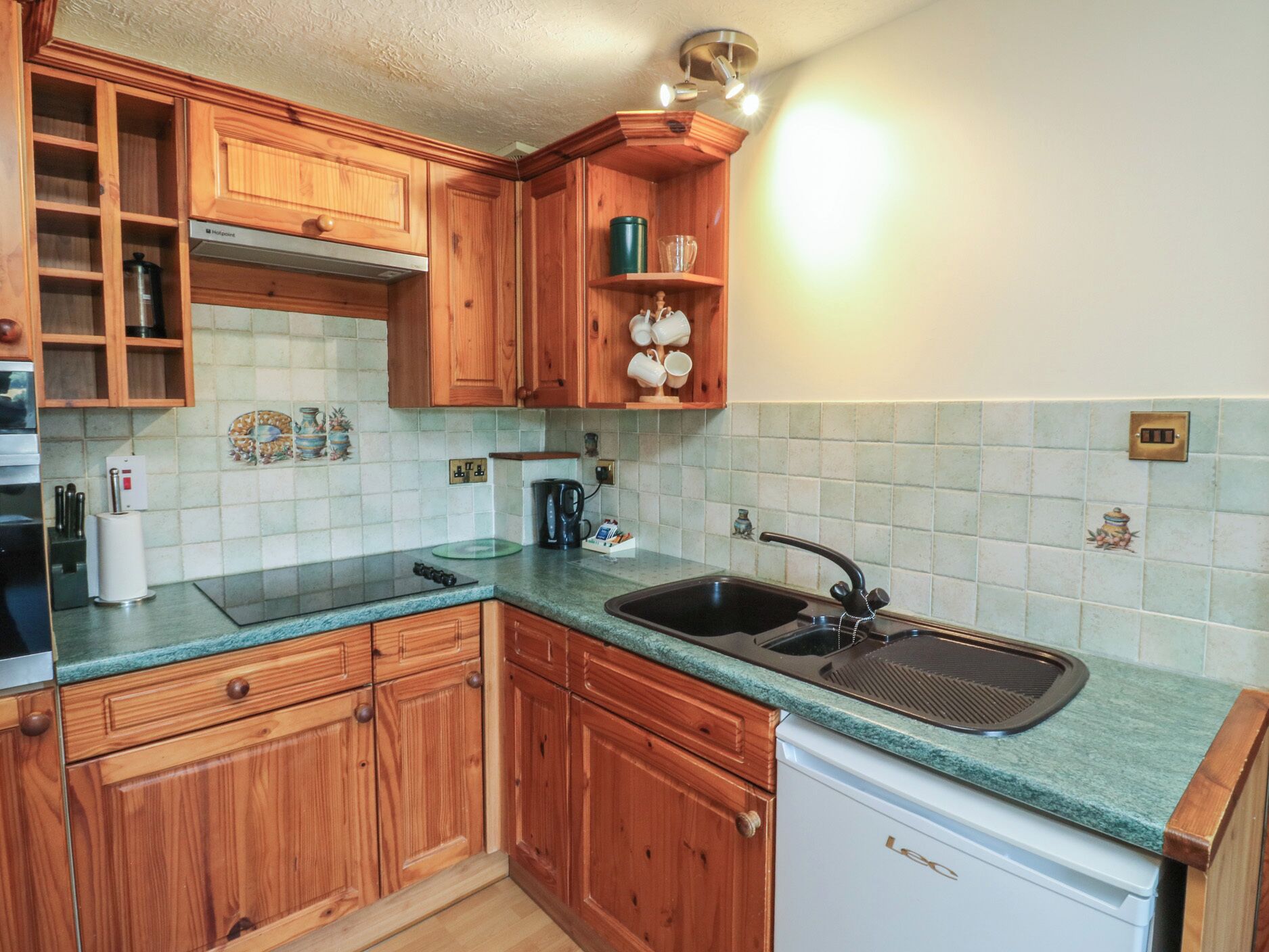 A kitchen with wooden cabinets, a sink, and a dishwasher.