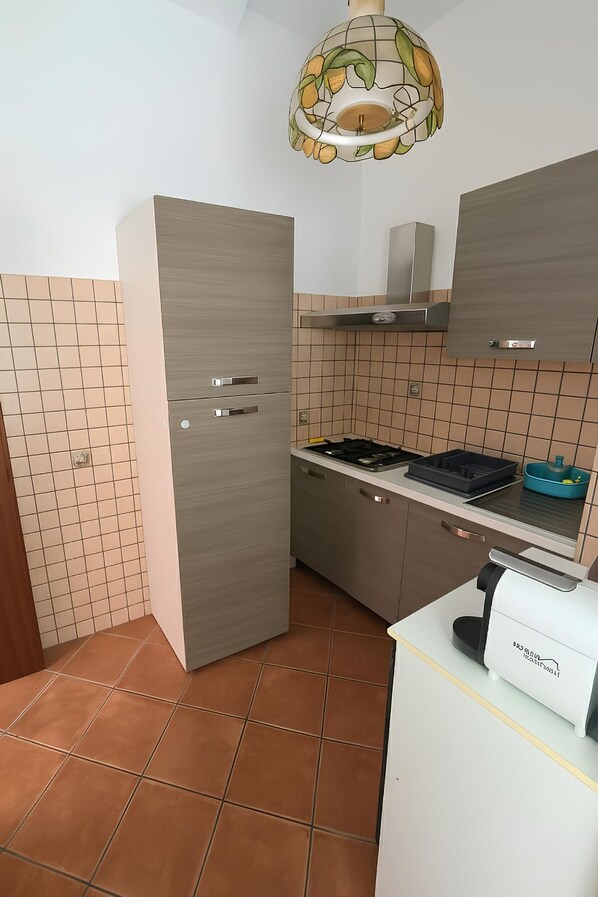 Una cocina compacta con horno integrado, microondas y pileta.