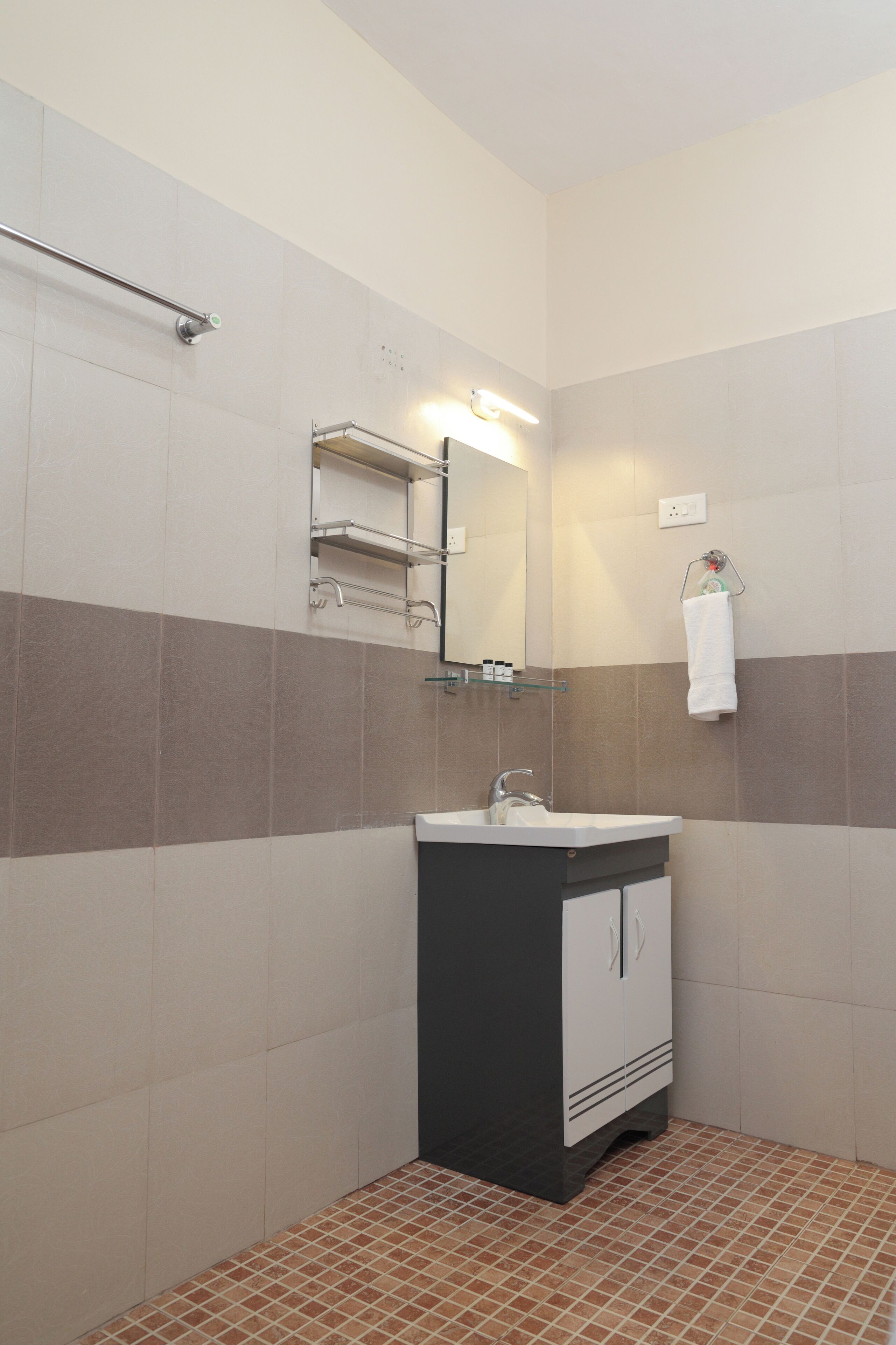 A bathroom with a sink, mirror, towel rack, and tiled walls.