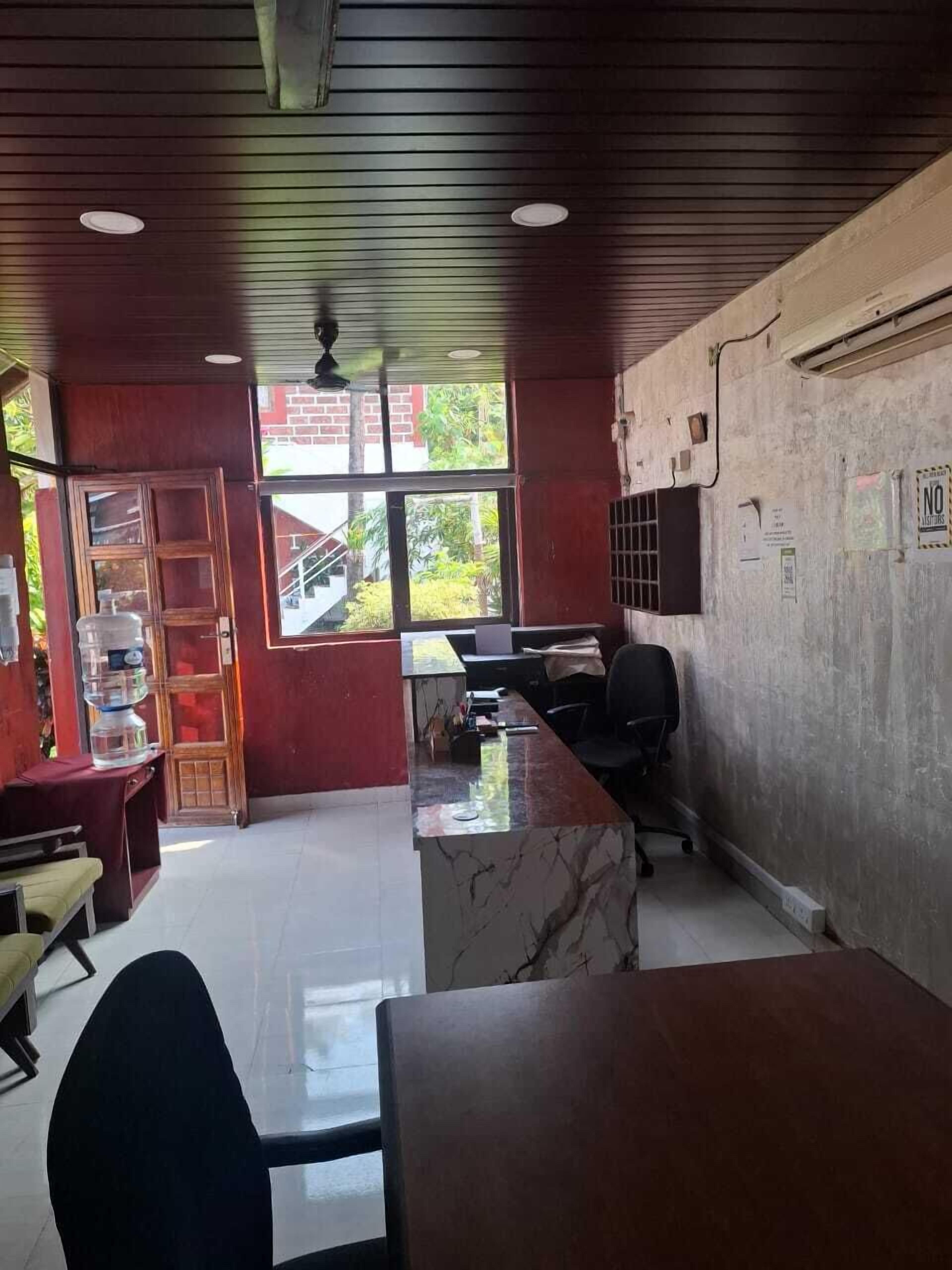 A reception area with a marble counter, a black office chair, and a water dispenser.