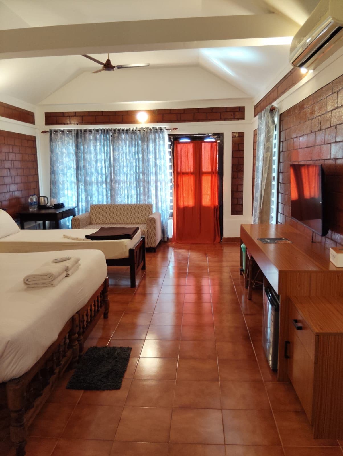 Una habitación de hotel con una cama, un sofá, un escritorio y un televisor.