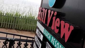 A beach resort sign with amenities including rooms, ayurveda, restaurant, and yoga.