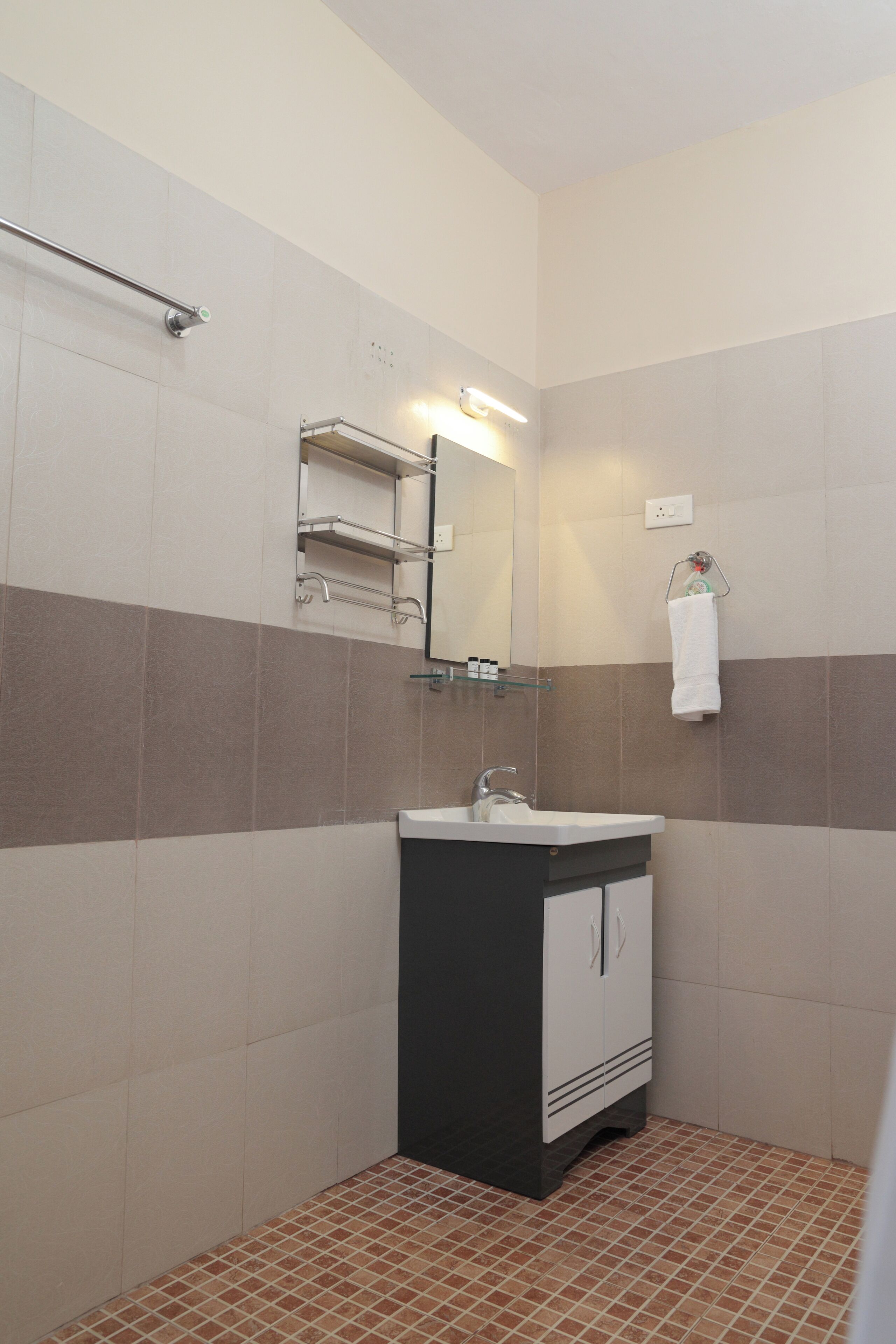 A bathroom with a sink, mirror, towel rack, and tiled walls.