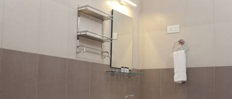 A bathroom with a sink, mirror, towel rack, and tiled walls.