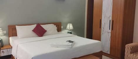Un dormitorio con cama, mesitas de noche, armario y equipo de aire acondicionado.