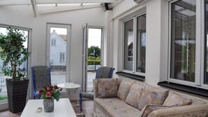 A sunlit room with a sofa, chairs, a table, and a potted plant. - Lovely home in Höganäs with WiFi (Höganäs)