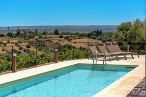 Piscine extérieure en saison, chaises longues