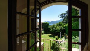 Une vue depuis un balcon, avec un ciel dégagé, un lac et des montagnes à l’horizon.