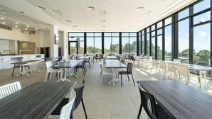 A spacious dining area with high ceilings and large windows offering a view of the outdoors. - MAMAD - Keshet Eilon View Retreat by Sea N' Rent (Eilon)