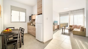 A modern apartment with a kitchen, dining area, and living room.