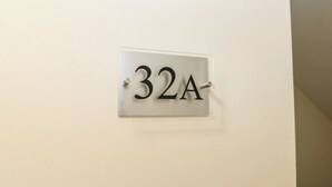 A metal number plate with the number 32A mounted on a wall. - Curwen Apartment (Workington)