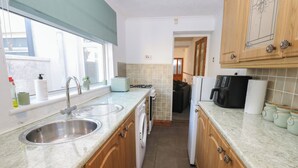 Eine kleine Küche mit Spüle, Toaster, Kaffeemaschine und Kühlschrank.