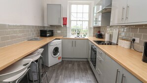 Una cocina compacta con lavadora, microondas y lavabo.