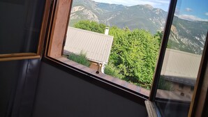 Una habitación con ventana que da a un paisaje montañoso.